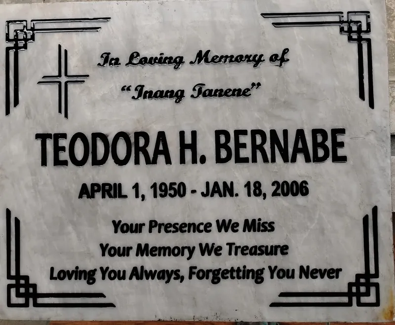 White veined marble lapida with bold black engraved lettering and geometric corner borders